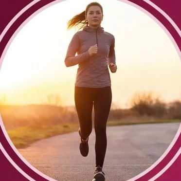 Woman jogging on a country road at sunrise