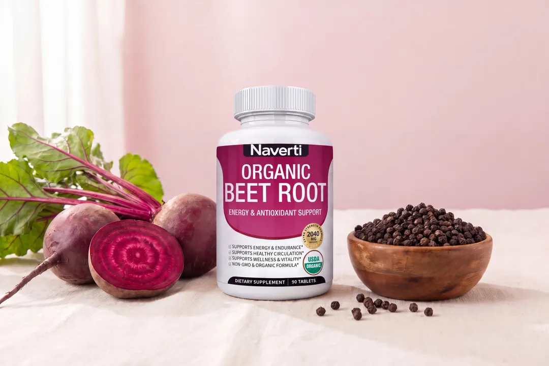 Naverti bottle between fresh beetroots and a wooden bowl of black peppercorns